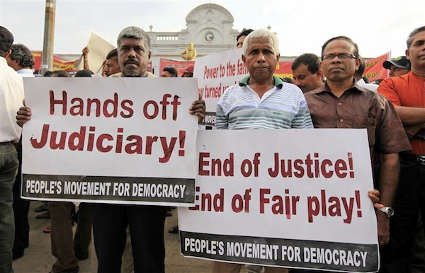 Opposition activists hold up placards during a protest in Colombo
