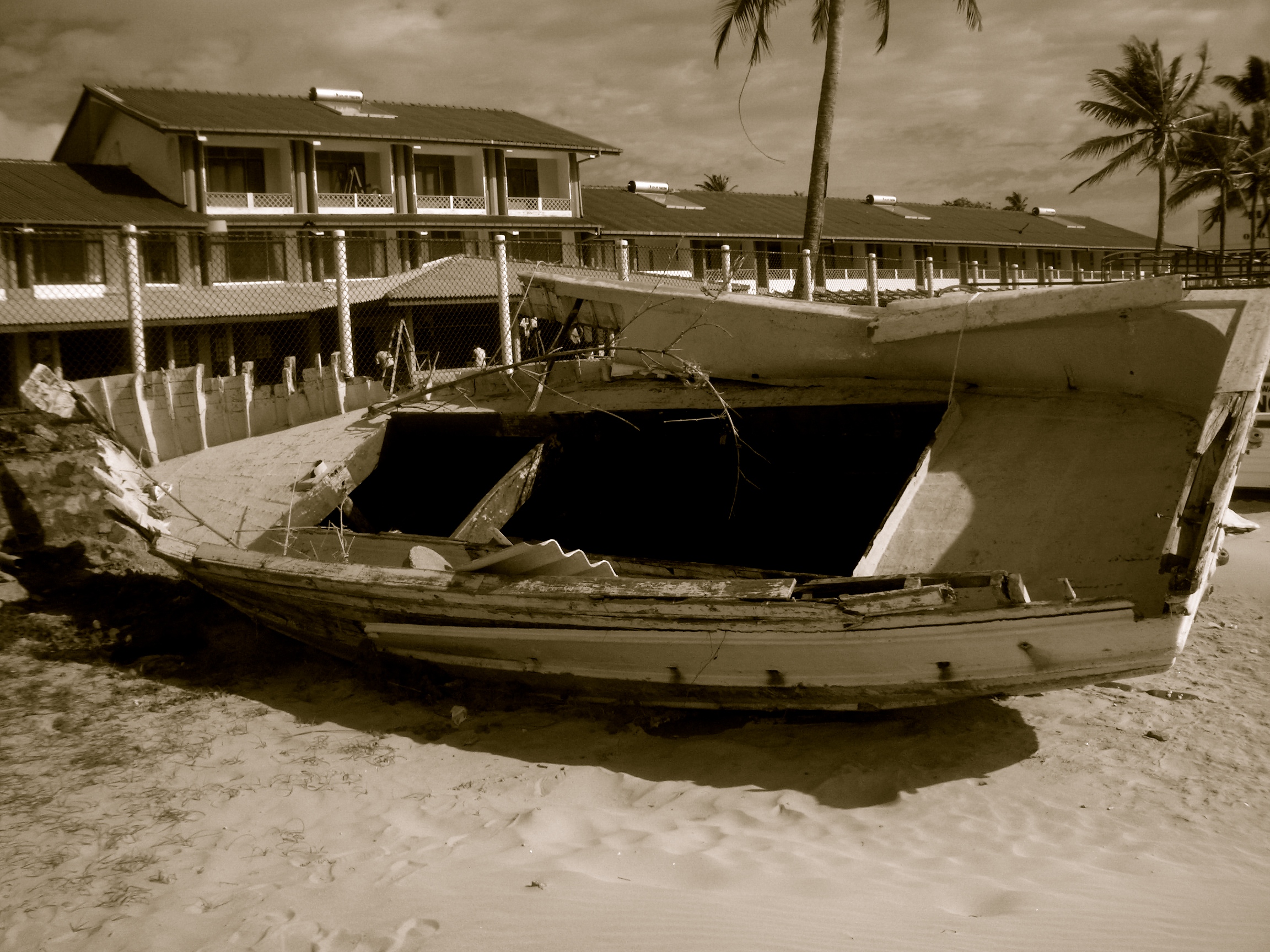 A boat lies in ruins on a beach in the South.